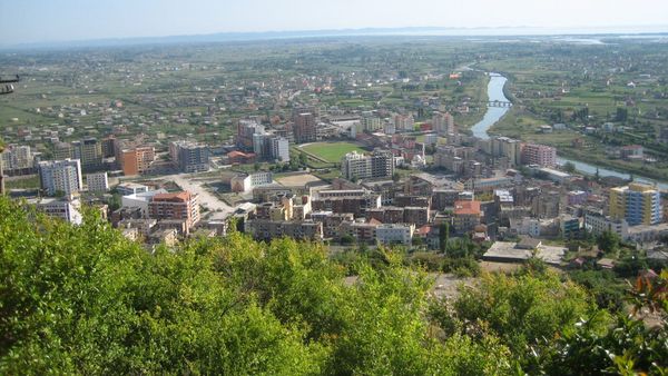 Pamje e Lezhës nga kodra e kalasë: pallatet e qytetit, stadiumi, Drini i Lezhës dhe fusha deri në det