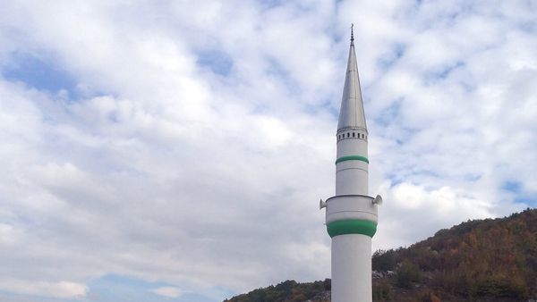 Xhamia e fshatit Carralevë me minare të bardhë, rrëzë kodrave me pyll në grykën e Carralevës