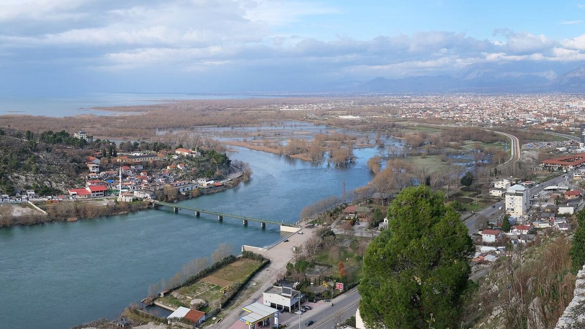 Pamje e Shkodrës nga muret e kalasë së Rozafës: Buna me urën, liqeni, qyteti dhe malet në sfond